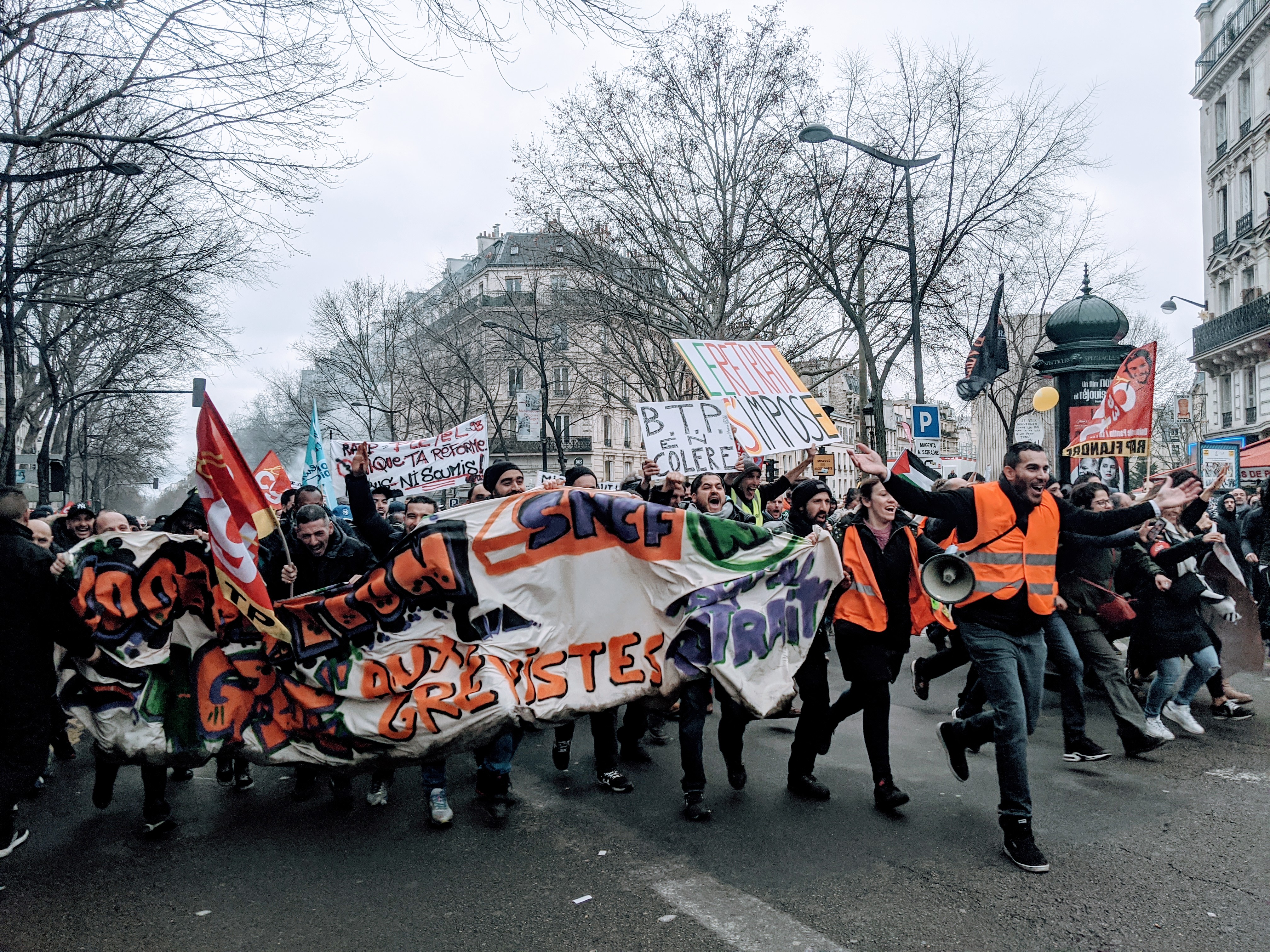 French rail workers running in a strike rally, January 9