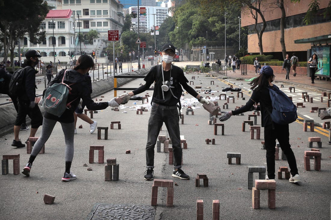 Students use bricks to barricade the road near the occupied Hong Kong Polytechnic.